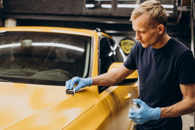 Technician performing ceramic coating procedure on a car for long-lasting protection